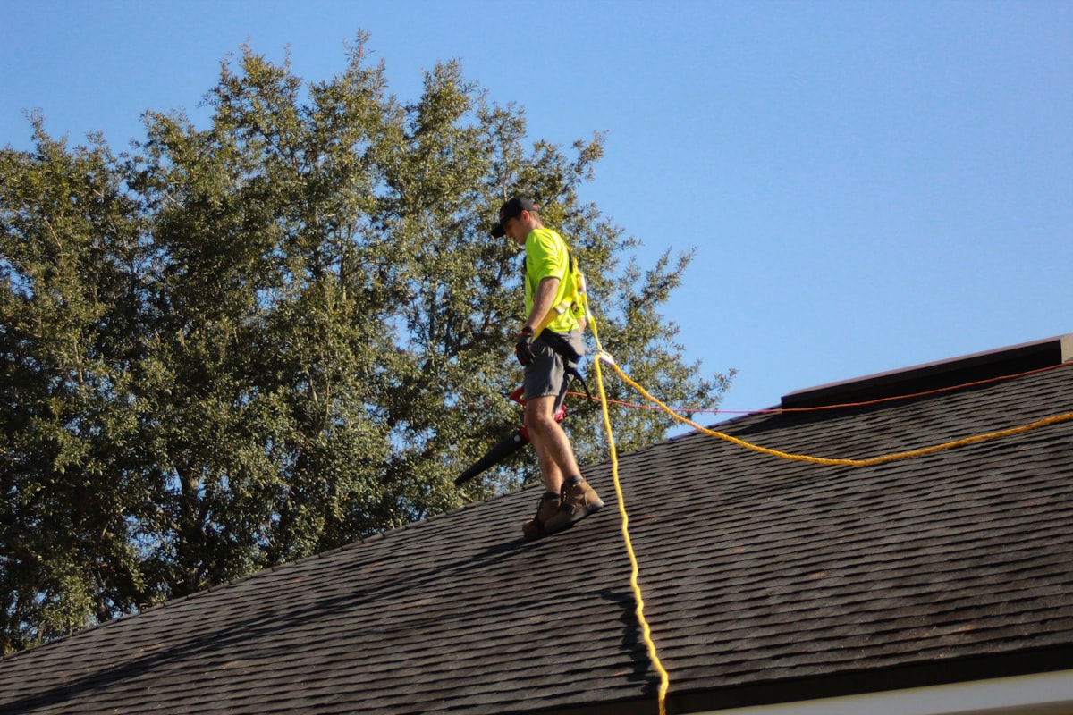 Roofer repairing architectural shingles on a residential roof
